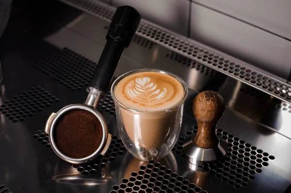 Tampon et tasse à café remplis de latte décoré sur le comptoir — Photo