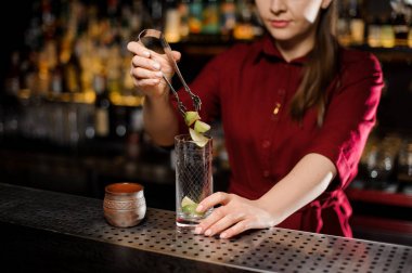 Üç adet kireç bir cam içine koyarak kadın barmen