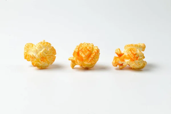 Три шматочки смачного попкорну на білому тлі — стокове фото
