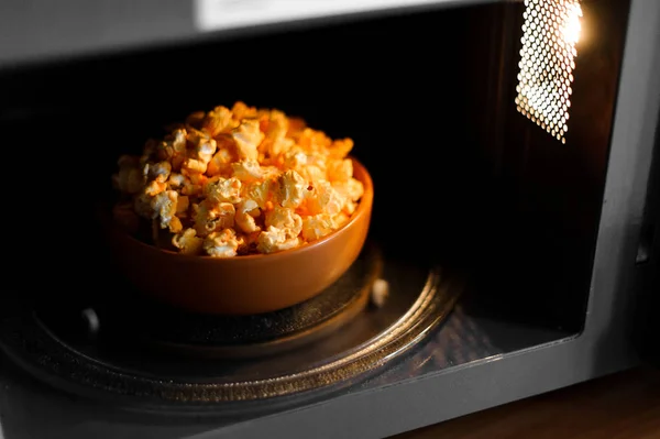 Schüssel mit leckerem Popcorn in der Mikrowelle — Stockfoto