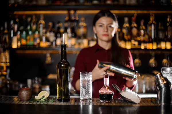 Mulher barman sacudindo o coquetel no balcão do bar — Fotografia de Stock