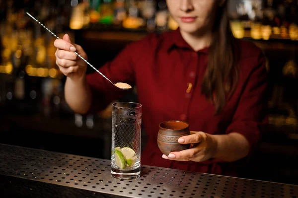 Barkeeperin steckt einen Rohrzucker in ein Glas — Stockfoto