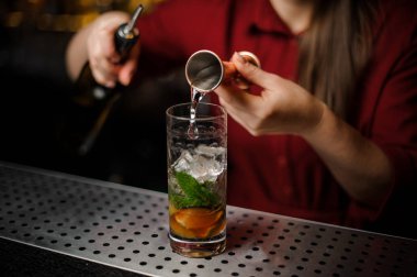 Kadın barmen ölçüm kazık alkollü bir içki dökülen