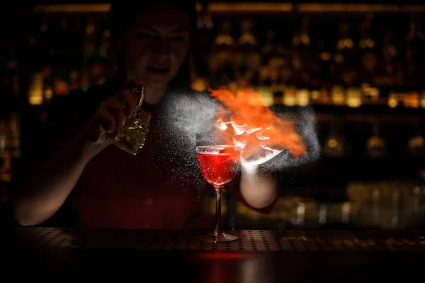 Vrouwelijke bartender sproeien op de cocktail en het in brand gestoken — Stockfoto