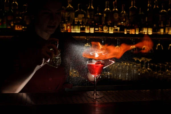 Vrouwelijke bartender spuiten op en vastgestelde brand aan de cocktail — Stockfoto