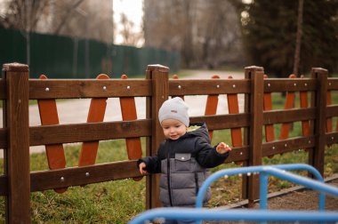 Küçük çocuk bir sıcak şapka ve arka plan üzerine ceket giymiş