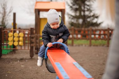 Salıncağa binmek ve aşağı bakıyor tatlı küçük çocuk