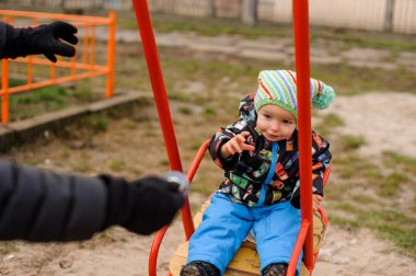 Bir hızıyla oturan küçük yürümeye başlayan çocuk