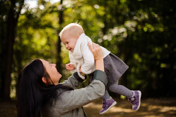 Morena mãe brincando com um bebê bonito filha — Fotografia de Stock