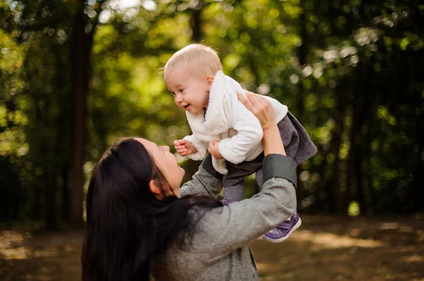 Happy brunette mother playing with a cute baby daughter — Stock Photo, Image