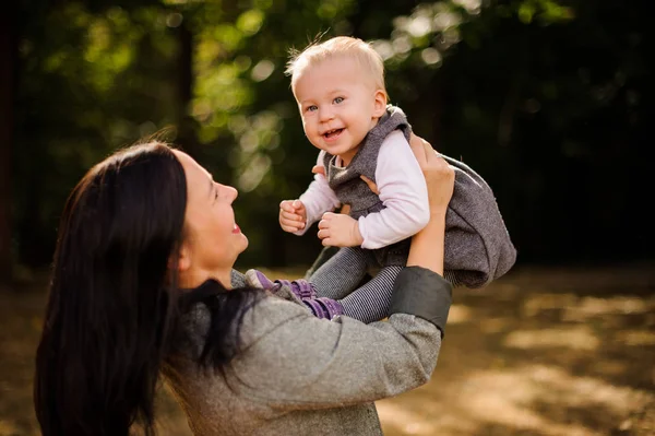 Happy brunetka matka hraje s dcerou smějící se miminko — Stock fotografie