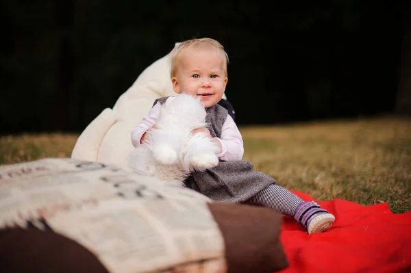 Niña sentada en una manta en el parque — Foto de Stock