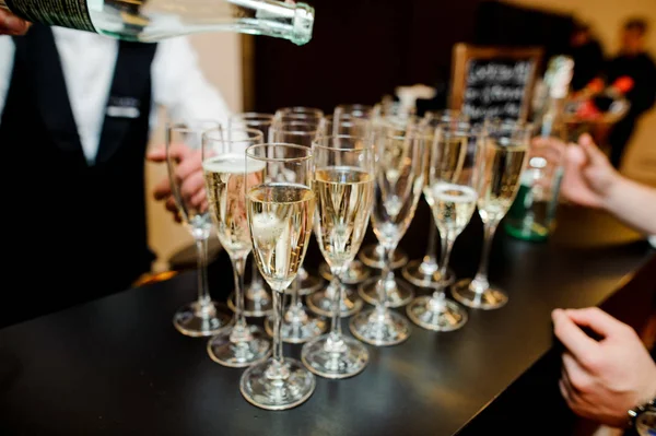 Barman derramando champanhe em vidro no bar — Fotografia de Stock