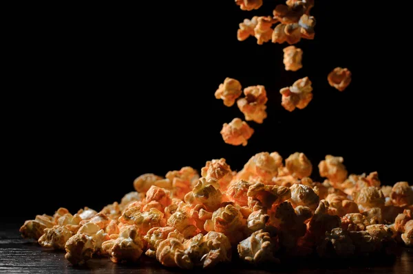 Puszyste sztuk popcorn zakochać się w zwolnionym tempie na czarnym tle — Zdjęcie stockowe