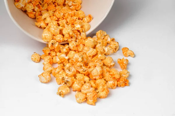 Gele heerlijke geroosterde popcorn verspreid van een emmer op een witte achtergrond — Stockfoto