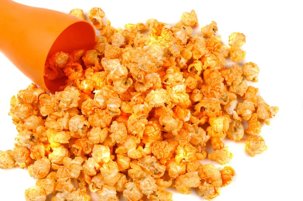 Ziarno żółte palona popcorn rozrzucone z pomarańczowego szkła — Zdjęcie stockowe