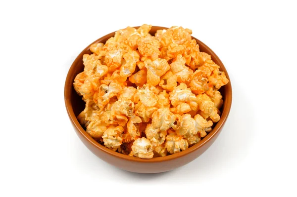 Heerlijke, kruidige popcorn in een bruin kleiplaat op een witte achtergrond — Stockfoto