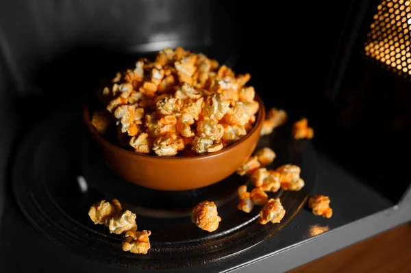 Geroosterde popcorn in een klei bruin schotel stand in de magnetron — Stockfoto