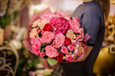 Güzel bir buket pembe ve kırmızı çiçek tutan kız