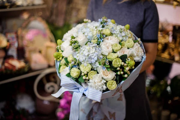 Chica sosteniendo un ramo de ranunkulus blancos y verdes y hortensias azules —  Fotos de Stock