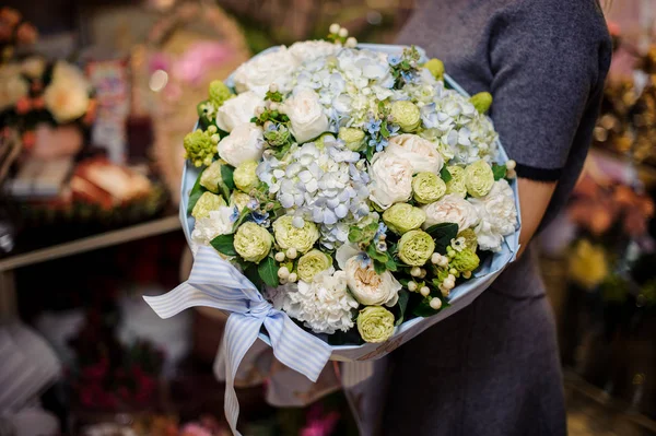 Girl holding a bouquet of white ranunkuluses and blue hydrangeas — Stock Photo, Image