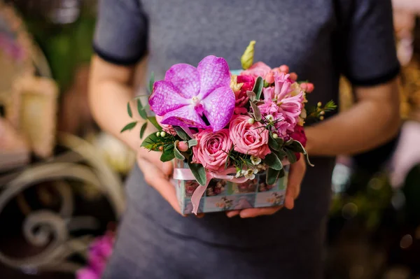 Chica sosteniendo una pequeña hermosa caja de flores — Foto de Stock