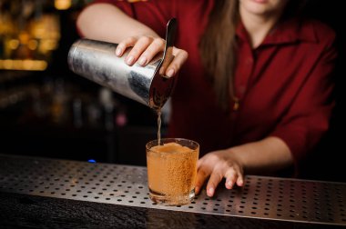 Barmen kız bir kokteyl dekore edilmiş cam içine doldurma