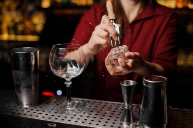 Barmen kız bir buz küpü kokteyl için kırma