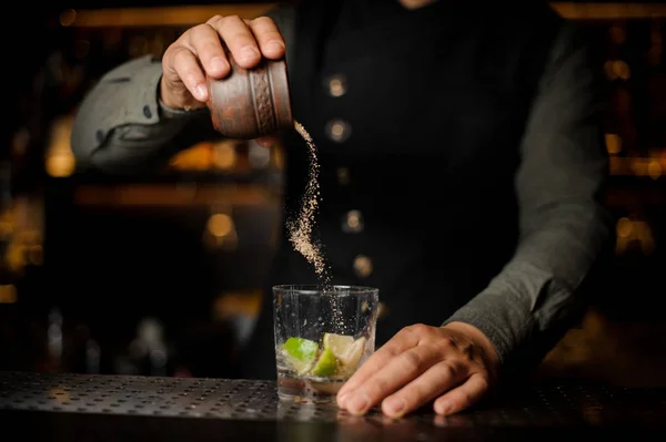 Barman añadiendo un azúcar de caña en la copa de cóctel con lima — Foto de Stock