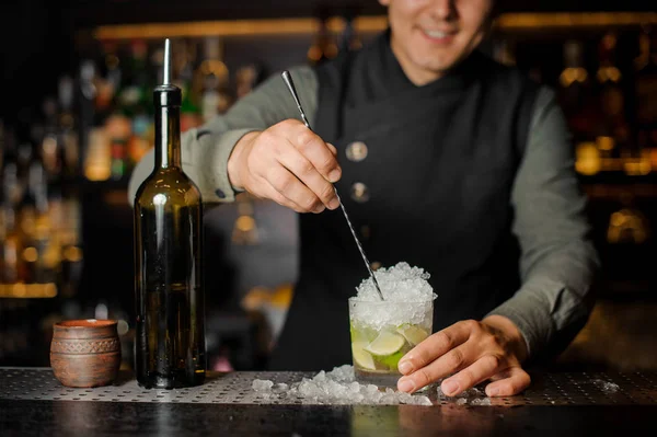 Barman revolviendo un delicioso cóctel fresco con lima — Foto de Stock