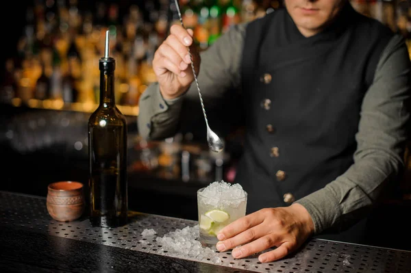 Barman revolviendo un delicioso cóctel fresco con limón y caña de azúcar — Foto de Stock