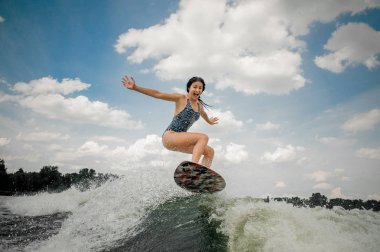 Genç kadın üzerinde kurulu wakesurfing RI üzerinde atlama çığlık