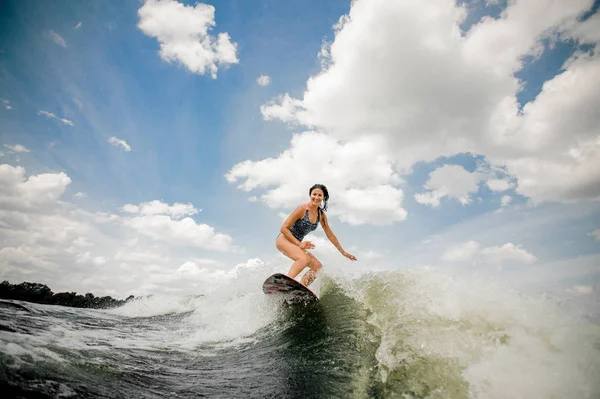 Mosolygó nő wakesurfing a fedélzeten, az ég ellen — Stock Fotó