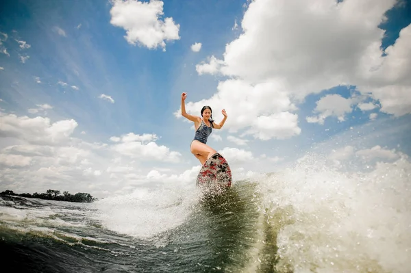 Belle jeune femme qui s'amuse à se réveiller et à sauter sur la planche — Photo