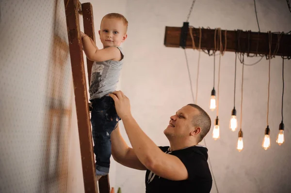 아버지 집에서 돕는 사다리를 등반 하는 그의 작은 아들 — 스톡 사진