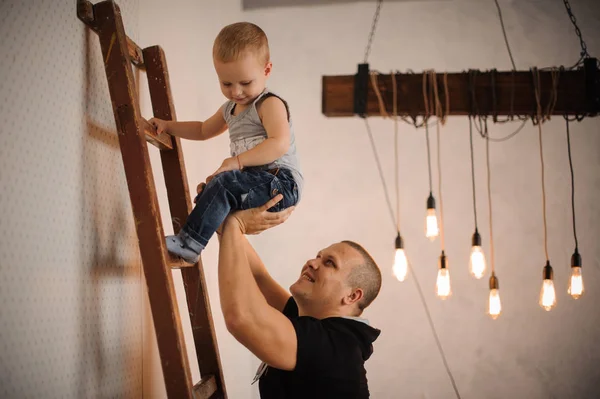 사다리를 등반 하는 그의 작은 아들을 돕는 아버지 — 스톡 사진