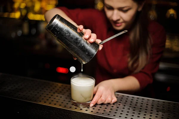 Barman feminino derramando uma última gota do coquetel da coqueteleira — Fotografia de Stock