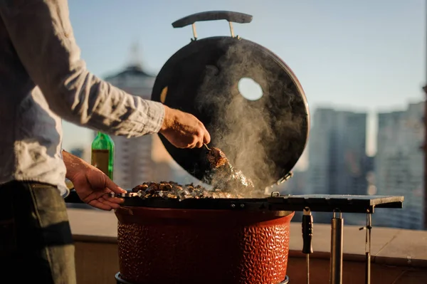 Человек готовит блюдо в гриле барбекю оснащены приготовления пищи тоже — стоковое фото