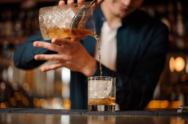 Taze ve soğuk alkollü içecek bir bardak içine dökme barmen