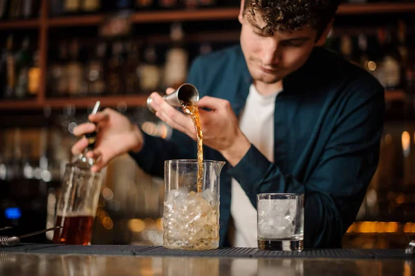 Barman riccio versando sciroppo dolce in un barattolo con ghiaccio facendo una bevanda alcolica — Foto Stock