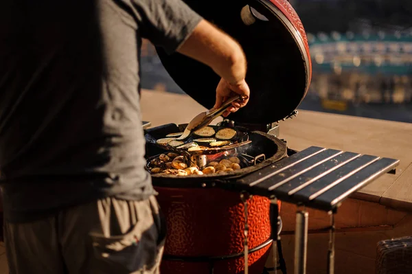 Homem cozinhar pimentas, cogumelos e berinjelas na grelha — Fotografia de Stock