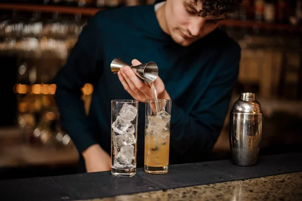 Bartender med lockigt hår börjar förbereda två alkoholhaltiga drinkar — Stockfoto