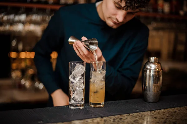 Camarero con el pelo rizado comienza a preparar dos cócteles alcohólicos — Foto de Stock