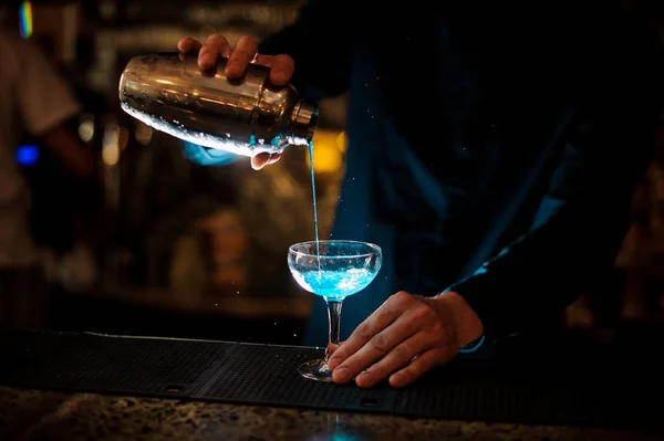 Barman vierte de un agitador en un vaso de cóctel de alcohol Blue Lagoon —  Fotos de Stock