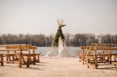 Ahşap banklar ve el yapımı arch ile Avrupa düğün töreni için şık açık alan