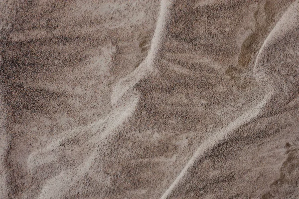 Ovanifrån texturerat bakgrund av våta havet sand blandat med lite stenar i vackra mönster — Stockfoto