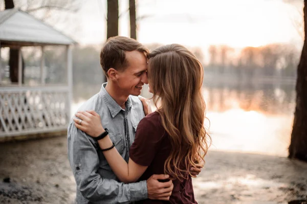 Par i kärlek kramar varandra på bakgrunden av sjön — Stockfoto