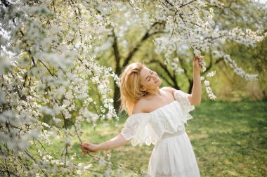 Gülümseyen kız güzel beyaz ağaç dalları arasında ayakta