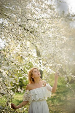 Güzel beyaz ağaç dalları arasında duran ve seyir kız