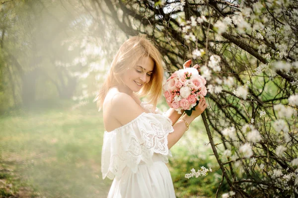 Souriante fille debout entre les branches de l'arbre blanc — Photo